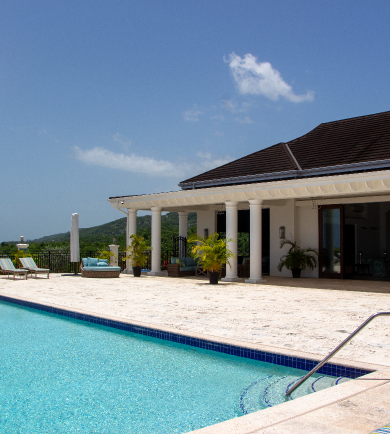 Sunlit villa patio with swimming pool, lounge chairs, and columns under a blue sky